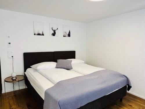 a bedroom with a bed with a blue blanket at La Tgoma - Hotel & Restaurant in Lenz