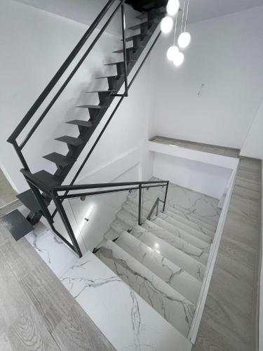 una scala con ringhiera in vetro e pavimento in marmo di Vanex a Petricani