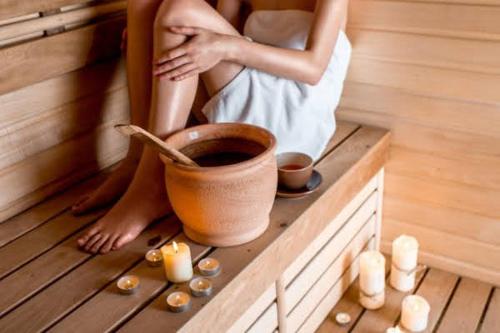 a woman is sitting in a sauna at Free wellness and saunapark Castle Resort Spa in Nyíregyháza