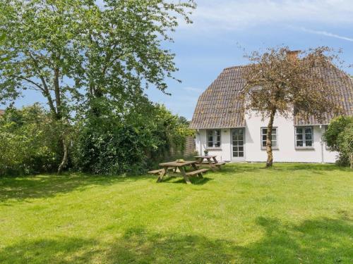 a picnic table in front of a white house at Holiday Home Ilja - 400m from the sea by Interhome in Sønderby