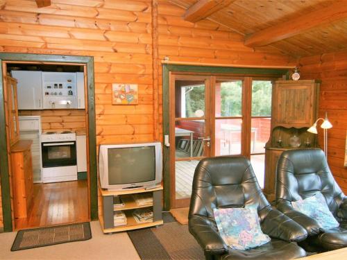 a living room with two leather chairs and a television at Holiday Home Byrge - 2km from the sea by Interhome in Fanø