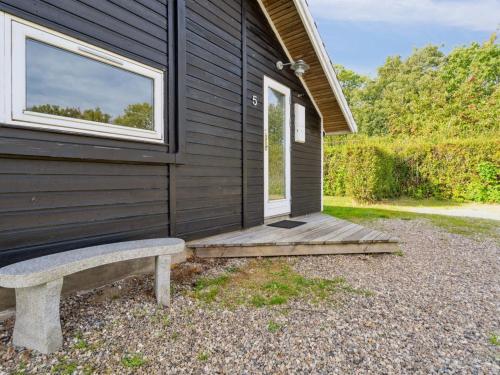 a bench sitting outside of a building with a window at Holiday Home Frosina - 300m from the sea by Interhome in Sarup