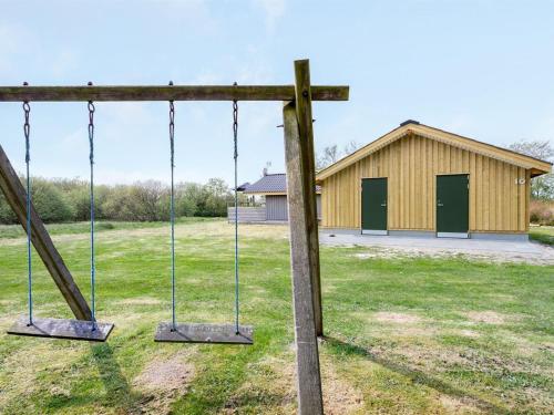 an empty swing in front of a building at Holiday Home Arona - 1-5km from the sea by Interhome in Fanø