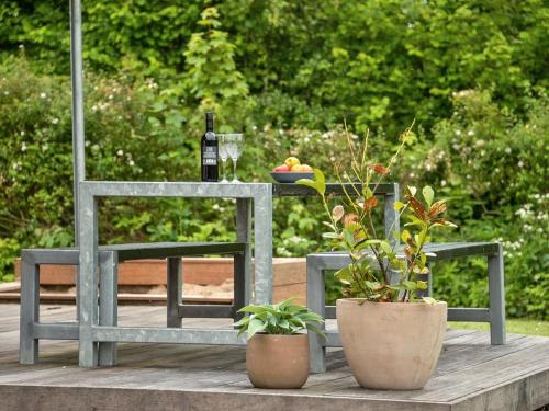 a table with two chairs and a glass of wine and plants at Holiday Home Annica - 150m from the sea by Interhome in Mommark