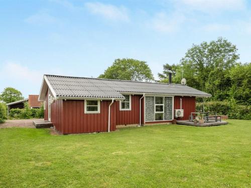 a red house with a large yard in front of it at Holiday Home Annica - 150m from the sea by Interhome in Mommark