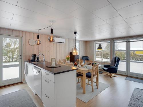a kitchen and dining room with a table and chairs at Holiday Home Leefke - 300m from the sea by Interhome in Sønderby