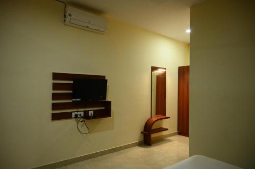 a room with a tv on the wall at The Royal Residency in Rājgīr