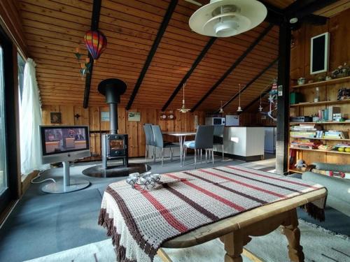 a living room with a table and a fireplace at Holiday Home Rieke - 300m from the sea by Interhome in Skovmose