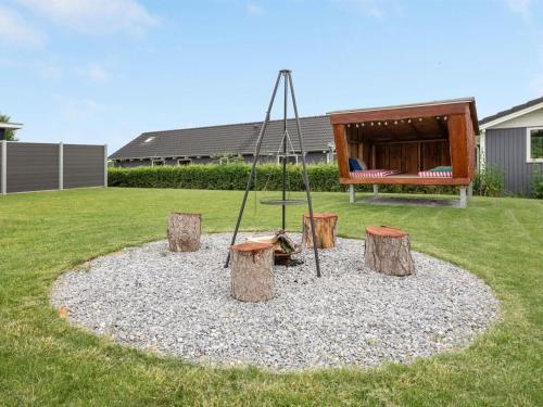 a playground with a swing in a yard at Holiday Home Tammo - 1km from the sea by Interhome in Neder Lysabild