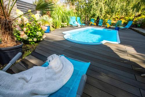 a hot tub on a deck with chairs next to it at Villa Santorini in Konarzyny