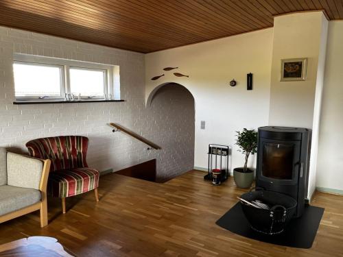 a living room with a fireplace and a couch and a tv at Holiday Home Edithe - 250m from the sea by Interhome in Augustenborg