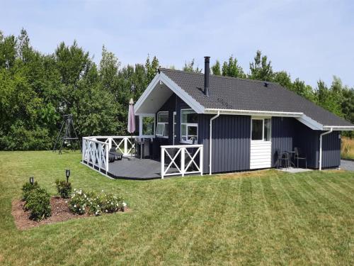 a small blue and white house with a yard at Holiday Home Gustava - 700m from the sea by Interhome in Neder Lysabild
