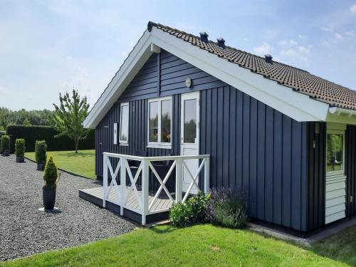 a black shed with a white door and windows at Holiday Home Gustava - 700m from the sea by Interhome in Neder Lysabild