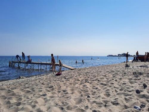 a group of people on a beach near the water at Holiday Home Gustava - 700m from the sea by Interhome in Neder Lysabild