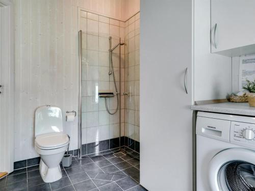 a bathroom with a toilet and a washing machine at Holiday Home Gustava - 700m from the sea by Interhome in Neder Lysabild