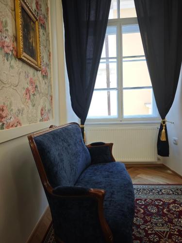 a living room with a chair and a window at Barbo Palace Apartments and Rooms in Ljubljana