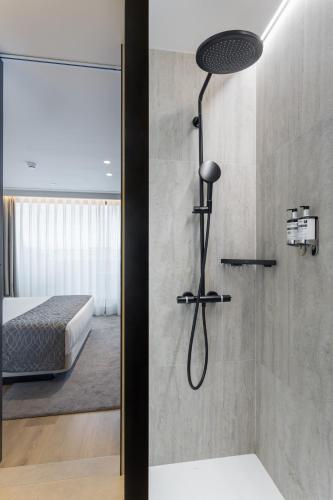 a shower in a bathroom with a bed in a room at Hotel Royal Passeig de Gracia in Barcelona