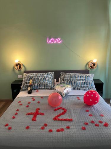 a bed with red rose petals on it at Altopiano Rooms Suite in Foggia