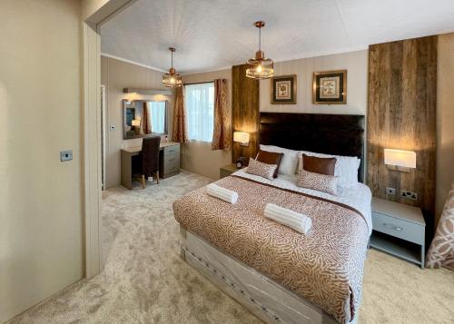 a bedroom with a large bed and a desk at Aber Bay Holiday Park in Aberystwyth