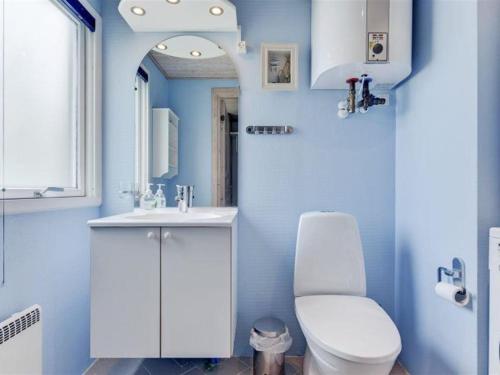 a blue bathroom with a toilet and a sink at Holiday Home Gudrid - 500m from the sea by Interhome in Fanø