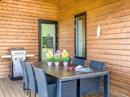 a wooden table with chairs and flowers on a patio at Holiday Home Gojana - 400m from the sea by Interhome in Nordborg