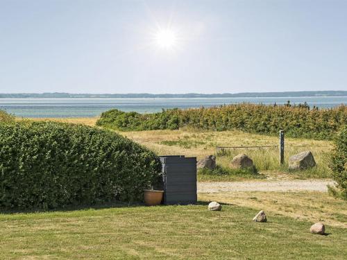 a wooden box sitting in the grass next to a bush at Holiday Home Kierstine - 100m from the sea by Interhome in Sønderby