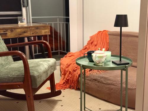a table with a candle on it next to a couch at The Grand Book Nook Retro Stay - Luxury King mattress with Flat TV - Private walk in book lounge & Study in Sydney