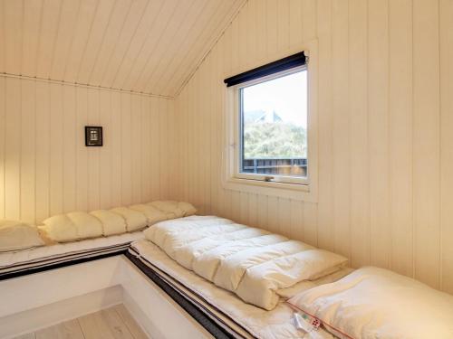 a room with four beds in a room with a window at Holiday Home Hansina - 500m from the sea by Interhome in Fanø