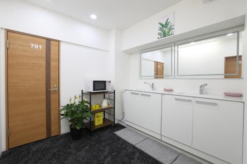 a kitchen with white cabinets and a wooden door at RH Tokyo Plus in Tokyo