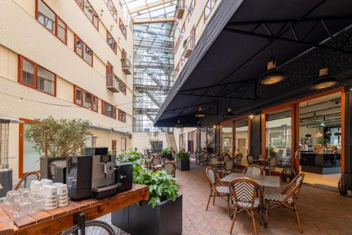 a patio with tables and chairs in a building at MyHotel Meppel in Meppel
