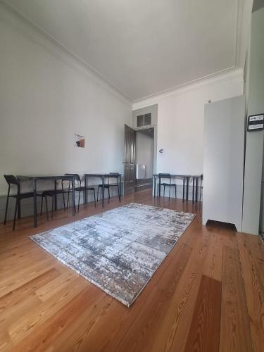 an empty room with a table and chairs and a rug at Easy Host Porto in Porto