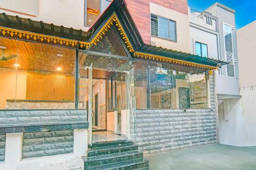 a house with a glass facade and stairs at Hotel O Mahakal in Ujjain
