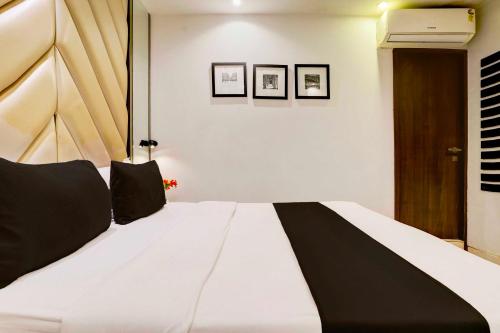 a large white bed with black pillows on it at Collection O Mumbai Central in Mumbai