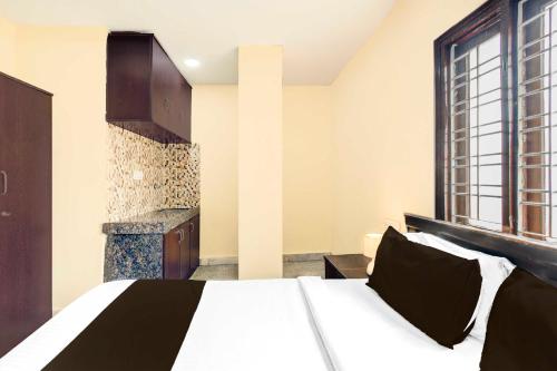 a bedroom with a large bed and a window at Hotel O Kothapet Near Omini Hospital in Hyderabad