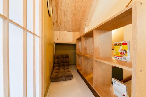 a room with wooden shelves with a chair in it at Tokyo Manga Stay 駅1分貸切で85平米 日本の有名マンガが読める宿 9名までOK in Tokyo