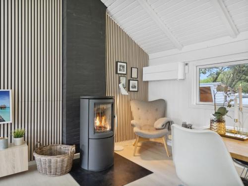 Una sala de estar con chimenea y una silla. en Holiday Home Julie - 1-5km from the sea by Interhome, en Fanø