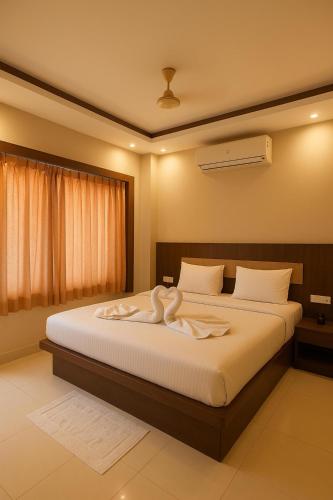 a bedroom with a bed with a towel on it at HOTEL SWARGADWAR GOLDEN SEA BEACH Near Bengali Market with Prime Location - Home town Inn & Suits - Best Hotel In Puri in Puri