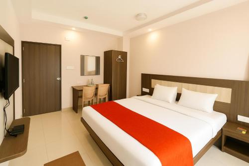 a bedroom with a large bed and a desk at HOTEL SWARGADWAR GOLDEN SEA BEACH Near Bengali Market with Prime Location - Home town Inn & Suits - Best Hotel In Puri in Puri