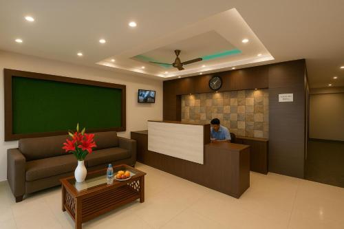 a man sitting at a desk in a waiting room at HOTEL SWARGADWAR GOLDEN SEA BEACH Near Bengali Market with Prime Location - Home town Inn & Suits - Best Hotel In Puri in Puri