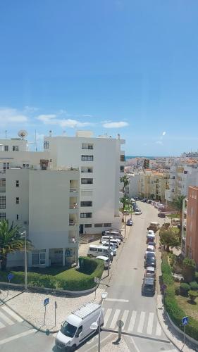 a city street with cars parked in a parking lot at Armaçao de Pera - T1 Proche Mer et commodités in Armação de Pêra