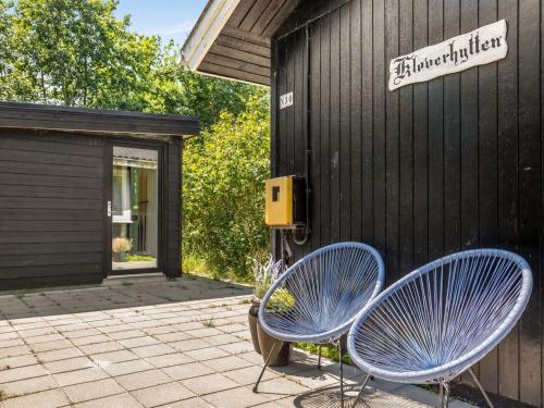 two blue chairs sitting outside of a building at Holiday Home Maik - 1-5km from the sea by Interhome in Fanø