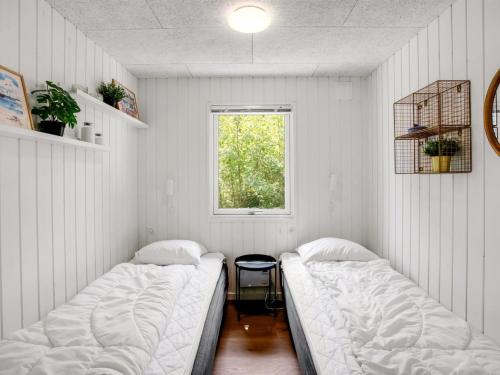 two beds in a room with a window at Holiday Home Maik - 1-5km from the sea by Interhome in Fanø
