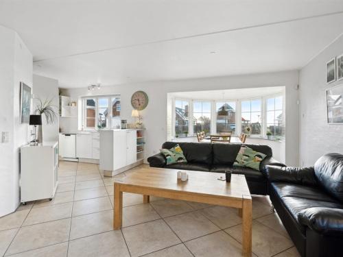 a living room with a black leather couch and a table at Holiday Home Joonas - 100m from the sea by Interhome in Havneby