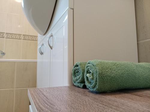a green towel sitting on a counter in a bathroom at Apartments Košević in Osijek