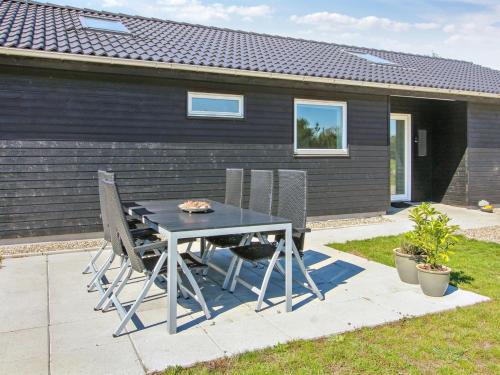 a table and chairs in front of a house at Holiday Home Anuk - 2-3km from the sea by Interhome in Rømø Kirkeby