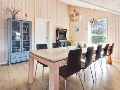 a dining room with a wooden table and chairs at Holiday Home Anuk - 2-3km from the sea by Interhome in Rømø Kirkeby