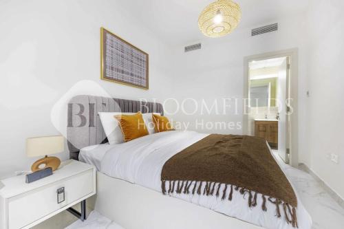 - une chambre blanche avec un lit et une table de nuit dans l'établissement Bloomfields Elegance 1br in Oasis Masdar, à Abu Dhabi