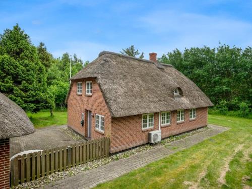 an old brick house with a thatched roof at Holiday Home Thoren - 2km from the sea by Interhome in Vesterhede
