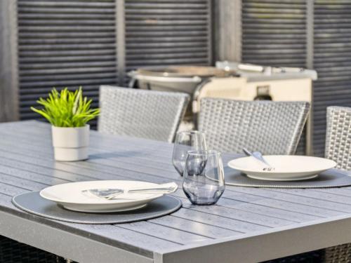 a wooden table with plates and wine glasses on it at Holiday Home Kita - 500m from the sea by Interhome in Lakolk