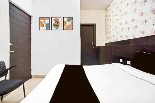 a bedroom with a bed and a chair at Super Collection O Prabhat Nagar Bareilly in Bareilly